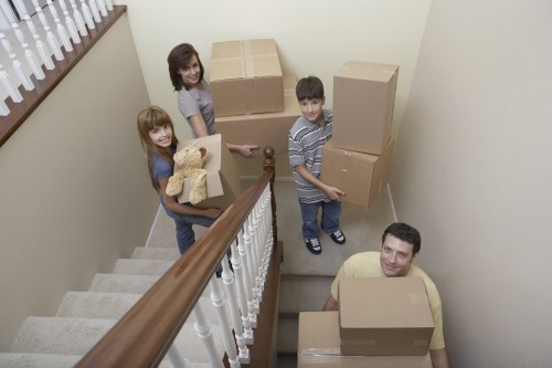 House movers carrying furniture through a Waterloo property with narrow access